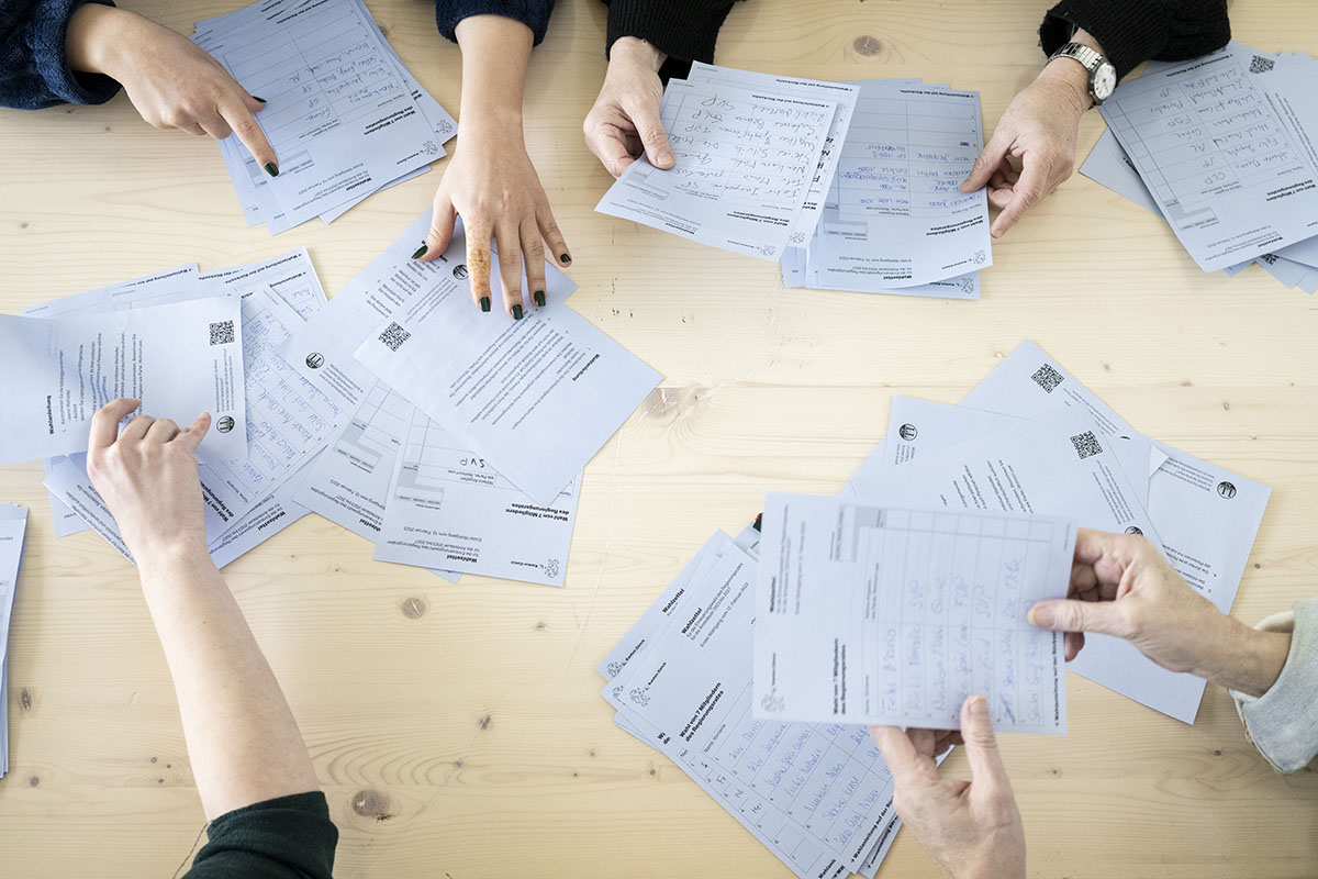 219864989 – Freiwillige Mitarbeiter helfen am 12. Februar 2023 beim Auslesen der Abstimmungsunterlagen zur Regierungs- und Kantonsratswahlen 2023 im Schulhaus Aemtler in Zürich. Foto: KEYSTONE | Ennio Leanza 219864989 – Freiwillige Mitarbeiter helfen am 12. Februar 2023 beim Auslesen der Abstimmungsunterlagen zur Regierungs- und Kantonsratswahlen 2023 im Schulhaus Aemtler in Zürich. Foto: KEYSTONE | Ennio Leanza