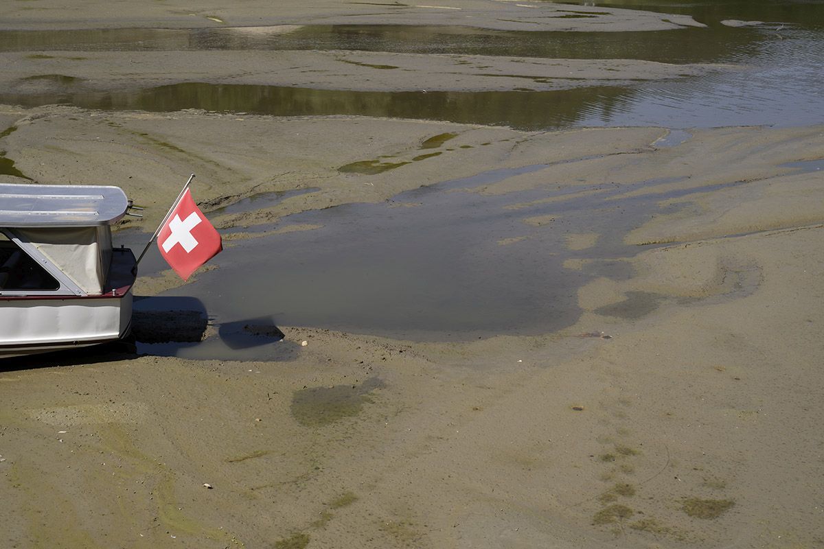 Aufgrund des niedrigen Wasserstandes steckt am 18. Juli 2022 ein Boot am ausgetrockneten Ufer des Lac des Brenets in der Nähe von La Chaux-de-Fonds fest. Der Lac des Brenets ist Teil des Flusses Doubs und bildet die natürliche Grenze zwischen Frankreich und der Schweiz. Foto: Keystone-SDA / Anthony Anex