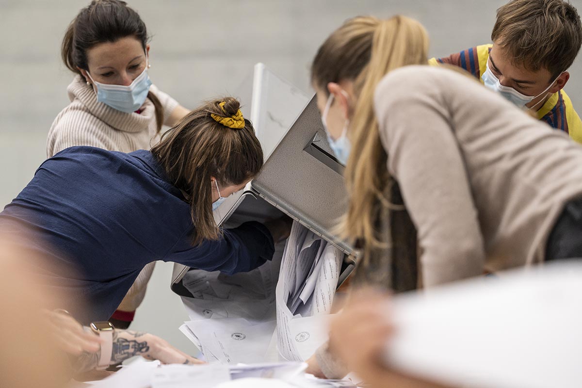 Des scrutatrices vident les bulletins de vote d'une urne sur la table pour le dépouillement. Photo prise à l'occasion des élections au gouvernement et au Grand Conseil le 27 mars 2022 à Berne. Photo : KEYSTONE / Alessandro della Valle