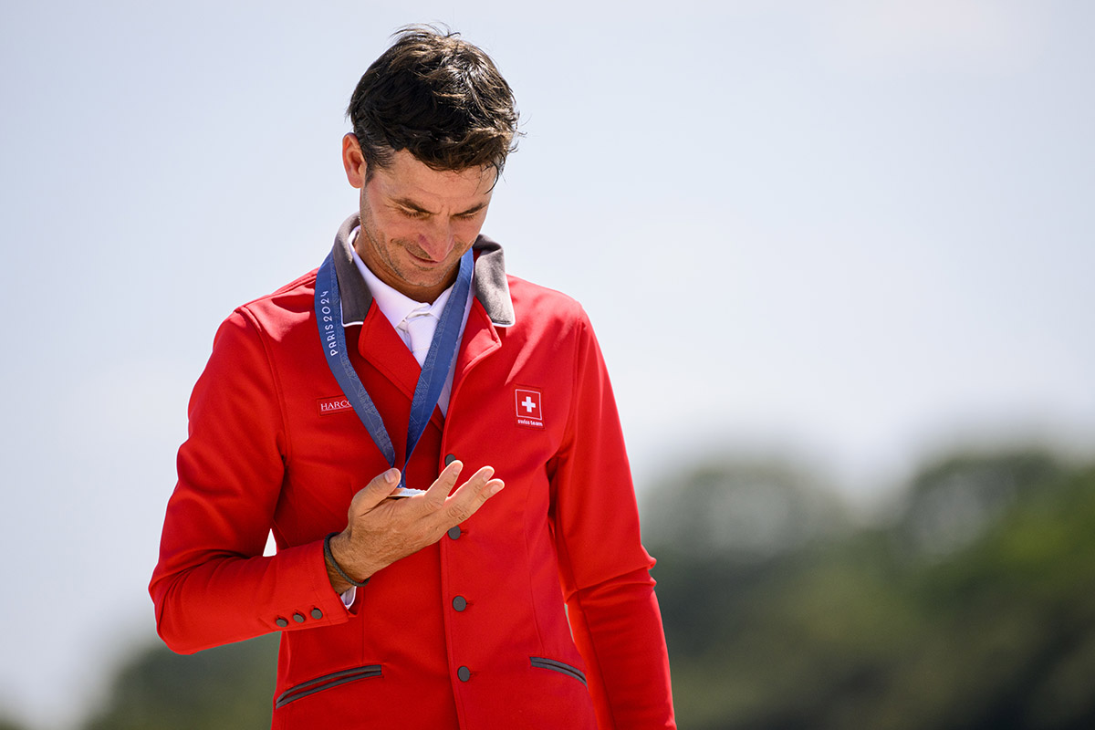 623042339 - Steve Guerdat (sur Dynamix De Belheme) célèbre sa médaille d’argent le 6 août 2024 lors de la cérémonie protocolaire de la finale individuelle de saut d’obstacles aux JO de Paris. Photo: KEYSTONE/ Laurent Gilliéron