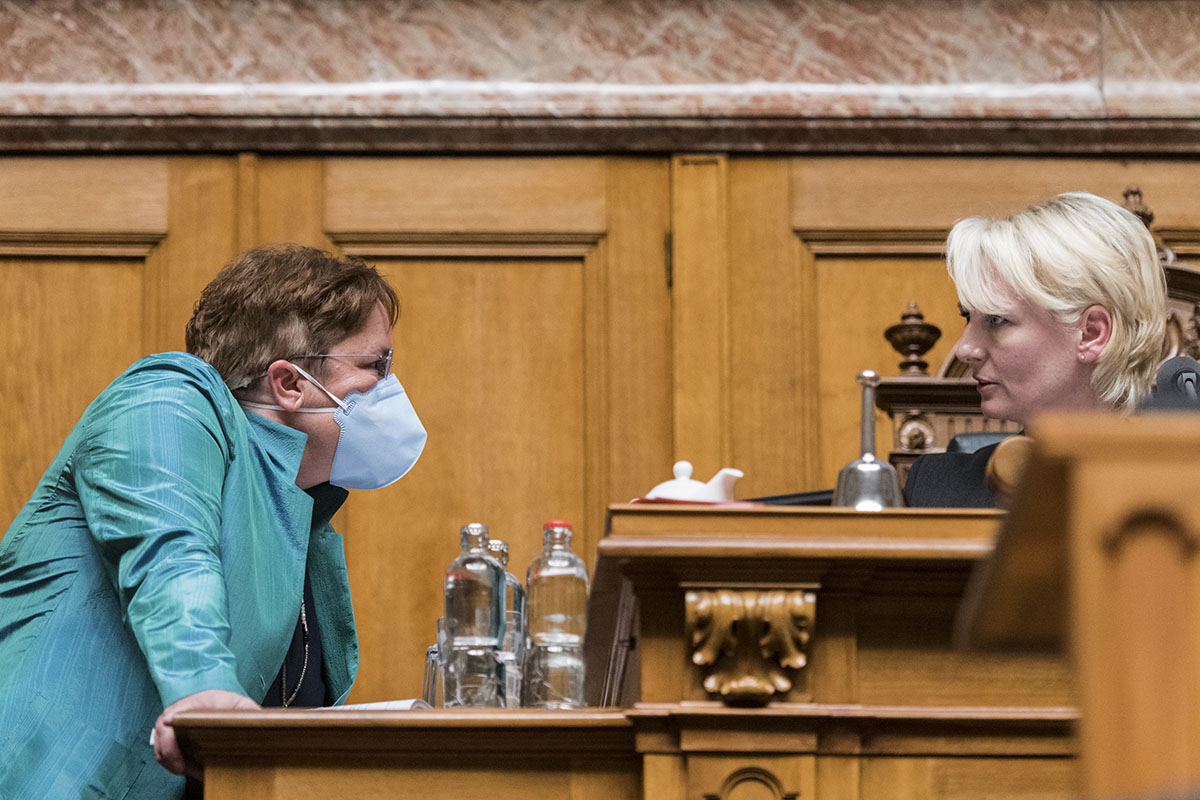 410280097 – Keystone-ATS/Alessandro della Valle  - Magdalena Martullo-Blocher, UDC-GR, à gauche, portant un masque respiratoire, en discussion le 2 mars 2020 avec la présidente du Conseil nationalIsabelle Moret, PLR-VD, le premier jour de la session de printemps de l'Assemblée fédérale à Berne.